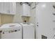 Convenient laundry room with white washer and dryer, upper cabinets, and easy access to the exterior at 2227 Doulton Dr, Orlando, FL 32812