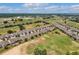 An aerial view of houses beside a golf course, with a highway and buildings visible in the distance at 2233 Antilles Club Dr, Kissimmee, FL 34747
