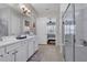Bright bathroom features double sinks, white cabinetry, walk-in shower, and access to main bedroom at 2233 Antilles Club Dr, Kissimmee, FL 34747