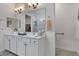 Bright bathroom features double sinks, white cabinetry, walk-in shower, and a neutral color palette at 2233 Antilles Club Dr, Kissimmee, FL 34747