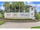 Community entrance with a water fountain, decorative signage, and beautiful landscaping at 2233 Antilles Club Dr, Kissimmee, FL 34747