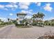Community entry gate with lush landscaping, palm trees, and elegant architecture at 2233 Antilles Club Dr, Kissimmee, FL 34747