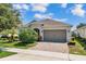 Charming home featuring a well-maintained lawn, a brick driveway, and an attached two-car garage at 2233 Antilles Club Dr, Kissimmee, FL 34747