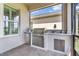 Outdoor kitchen featuring a stainless steel grill, refrigerator, and ample counter space at 2233 Antilles Club Dr, Kissimmee, FL 34747