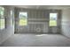 A spacious living room with large windows, awaiting finishing touches and personalization at 2365 Zuni Road, St Cloud, FL 34771