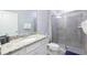 This bathroom showcases a toilet, granite countertop vanity, and walk-in shower at 271 Jetty Way, Davenport, FL 33897