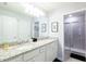 Bright bathroom features double sinks, granite countertops, framed mirror and walk-in shower at 271 Jetty Way, Davenport, FL 33897
