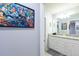 This bathroom boasts a granite vanity with double sinks, and Marvel themed wall art at 271 Jetty Way, Davenport, FL 33897