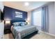 Beautiful bedroom featuring blue accent wall, stylish bedding, and lots of natural light from the window at 271 Jetty Way, Davenport, FL 33897