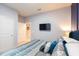 Tastefully decorated bedroom features cool color palette, tv, and doorway that leads to the rest of the house at 271 Jetty Way, Davenport, FL 33897