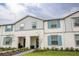 Inviting two-story townhome showcasing a charming exterior with light blue shutters and manicured landscaping at 271 Jetty Way, Davenport, FL 33897