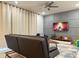 Comfortable living room featuring a modern ceiling fan and a decorative accent wall with curtains at 271 Jetty Way, Davenport, FL 33897
