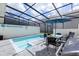 Inviting screened-in pool area with outdoor dining set and grill, perfect for entertaining and relaxation at 271 Jetty Way, Davenport, FL 33897