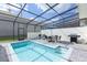 Inviting screened-in pool area with outdoor dining set and grill, perfect for entertaining and relaxation at 271 Jetty Way, Davenport, FL 33897