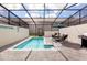 Inviting screened-in pool area with outdoor dining set and grill, perfect for entertaining and relaxation at 271 Jetty Way, Davenport, FL 33897