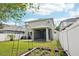 Backyard view of the home with a well-maintained lawn, patio, and white vinyl privacy fence at 2850 Pewter Mist Ct, Oviedo, FL 32765