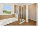 Bathroom featuring a soaking tub and glass-enclosed shower with natural light from a window at 2850 Pewter Mist Ct, Oviedo, FL 32765
