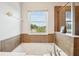Bright bathroom featuring a soaking tub, window view, and brown tiled accents at 2850 Pewter Mist Ct, Oviedo, FL 32765