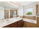 Bathroom with double sinks, large mirror, soaking tub, and a separate glass-enclosed shower at 2850 Pewter Mist Ct, Oviedo, FL 32765