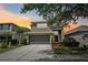 Beautiful two-story home with a well-manicured lawn and inviting two-car garage at sunset at 2850 Pewter Mist Ct, Oviedo, FL 32765