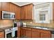 Close-up of the kitchen featuring dark wood cabinets, stainless steel appliances, and granite countertops at 2850 Pewter Mist Ct, Oviedo, FL 32765