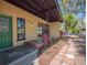 Close-up of the front porch with stone tiles, brick accents, and lush greenery enhancing the entrance appeal at 332 N Lakeland Ave, Orlando, FL 32805