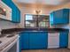 Kitchen with blue cabinets, granite countertops, stainless steel sink, and white appliances at 332 N Lakeland Ave, Orlando, FL 32805