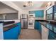 Bright kitchen featuring blue cabinetry, granite countertops, and stainless steel appliances at 332 N Lakeland Ave, Orlando, FL 32805