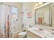 Bright bathroom featuring a shower-tub combo and vanity with a large mirror at 404 Sotheby Way, Debary, FL 32713
