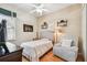 Cozy bedroom with wood floors, a comfortable chair, and ample natural light at 404 Sotheby Way, Debary, FL 32713