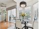 Bright breakfast nook featuring a glass table, modern chandelier, and scenic backyard views at 404 Sotheby Way, Debary, FL 32713