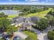 Aerial view of the grand community clubhouse boasting manicured landscaping, golf cart parking, and a circular driveway at 404 Sotheby Way, Debary, FL 32713