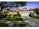 Charming single-story home featuring a well-manicured lawn, mature trees, and a two-car garage at 404 Sotheby Way, Debary, FL 32713