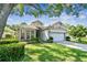 Inviting home with lush front lawn and landscaping, boasting a two-car garage and bright facade at 404 Sotheby Way, Debary, FL 32713