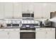 Updated kitchen with white cabinetry, granite countertops, and stainless steel appliances at 404 Sotheby Way, Debary, FL 32713