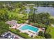 Aerial view of community pool with ample lounge seating and a covered pavilion near a lake and golf course at 404 Sotheby Way, Debary, FL 32713