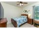 Cozy bedroom with a twin bed, wood furniture, ceiling fan, and playful dinosaur decor at 410 E Victoria Trails Blvd, Deland, FL 32724