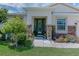 Inviting front entrance with a decorative green door, stone pillars, and lush landscaping at 410 E Victoria Trails Blvd, Deland, FL 32724