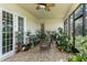 Enclosed patio filled with plants and wicker furniture for relaxing at 410 E Victoria Trails Blvd, Deland, FL 32724