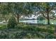 Picturesque pond view with a bench, mature trees, and well-maintained landscaping at 410 E Victoria Trails Blvd, Deland, FL 32724