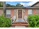 Close-up of a brick home entrance with peach shutters and well-maintained landscaping at 416 Banyon Tree Cir # 108, Maitland, FL 32751