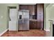 Kitchen featuring stainless steel refrigerator, dark wood cabinets, and adjacent laundry setup at 416 Banyon Tree Cir # 108, Maitland, FL 32751