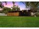 Modern home featuring a lush green lawn, minimalist landscaping, and a unique covered carport area at 4201 Mizell St, Orlando, FL 32812