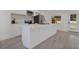 Modern kitchen featuring white cabinets, stainless steel appliances, and an island with a quartz countertop at 4201 Mizell St, Orlando, FL 32812