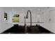 Close-up of a modern kitchen island with a black sink and sleek faucet, overlooking the living area at 4201 Mizell St, Orlando, FL 32812
