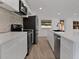 Modern kitchen with stainless steel appliances, a white quartz countertop, and an adjacent living area at 4201 Mizell St, Orlando, FL 32812