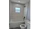Bathroom features tiled shower with black fixtures, decorative floor tiles, and white toilet and vanity at 468 Marion Oaks Blvd, Ocala, FL 34473