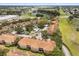 Aerial view of a well maintained community with lush landscaping, parking, and a lake in the distance at 527 Villa Del Sol Cir # 104, Orlando, FL 32824