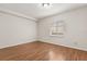 Cozy bedroom with hardwood floors, neutral walls, and bright window at 527 Villa Del Sol Cir # 104, Orlando, FL 32824