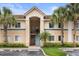Inviting condo exterior showcasing lush landscaping, palm trees, and well-maintained facade at 527 Villa Del Sol Cir # 104, Orlando, FL 32824
